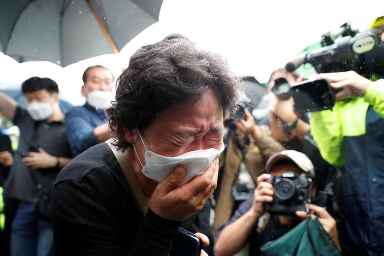 A woman mourns as the hearse carrying late Seoul Mayor Park Won-soon leaves Seoul City Hall Plaza after his funeral, in Seoul, South Korea. REUTERS/Kim Hong-Ji  
